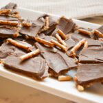 chocolate and peanut butter date bark topped with pretzels