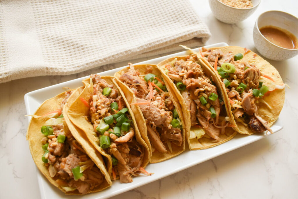 peanut chicken tacos served in corn tortillas