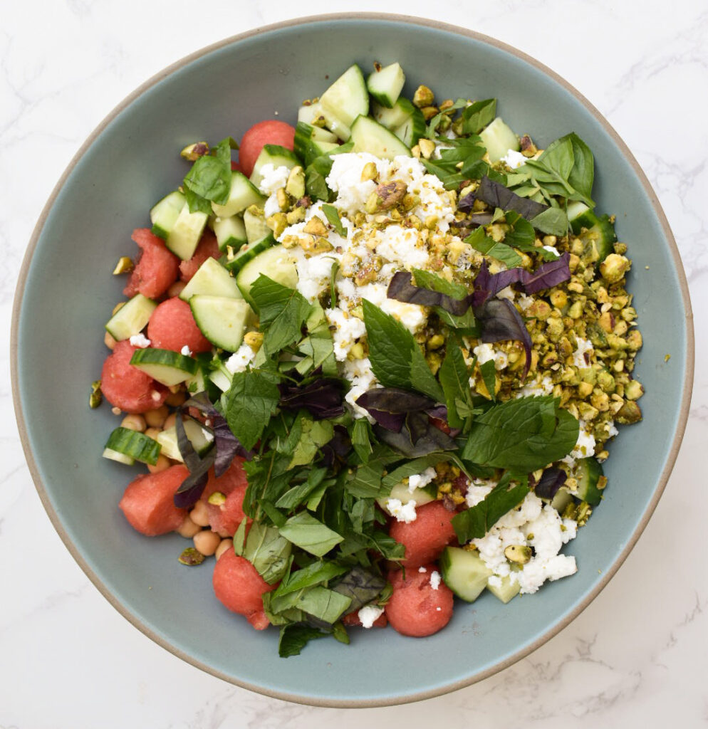 feta, watermelon, herbs, chickpeas, and pistachios for summer salad ready to be tossed