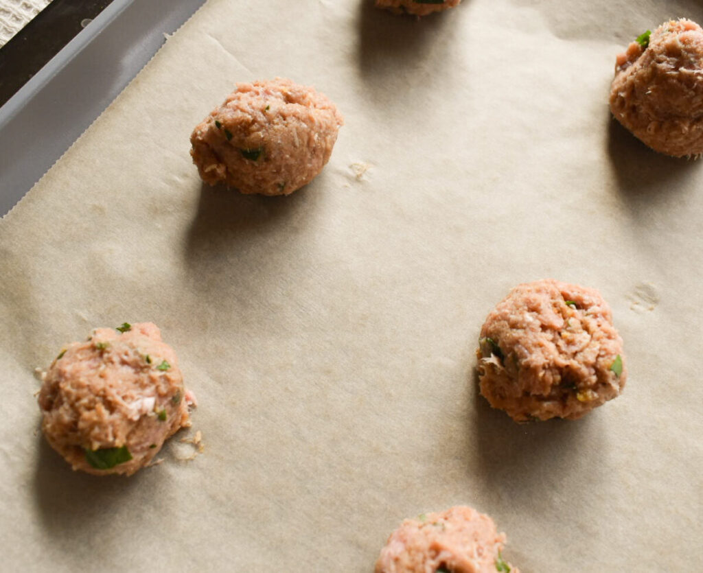 raw turkey meatballs on a baking sheet ready to be cooked