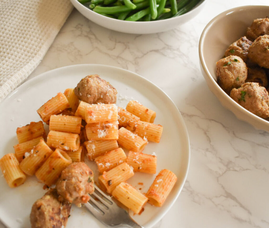 turkey meatballs made with hot honey, served with pasta and green beans
