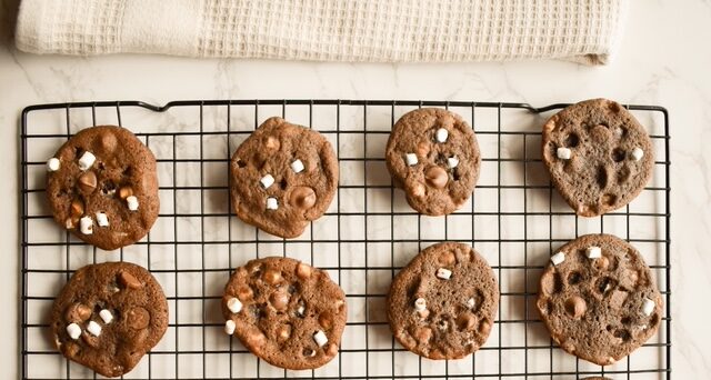 Chewy hot chocolate cookies with marshmallow bits on baking sheet