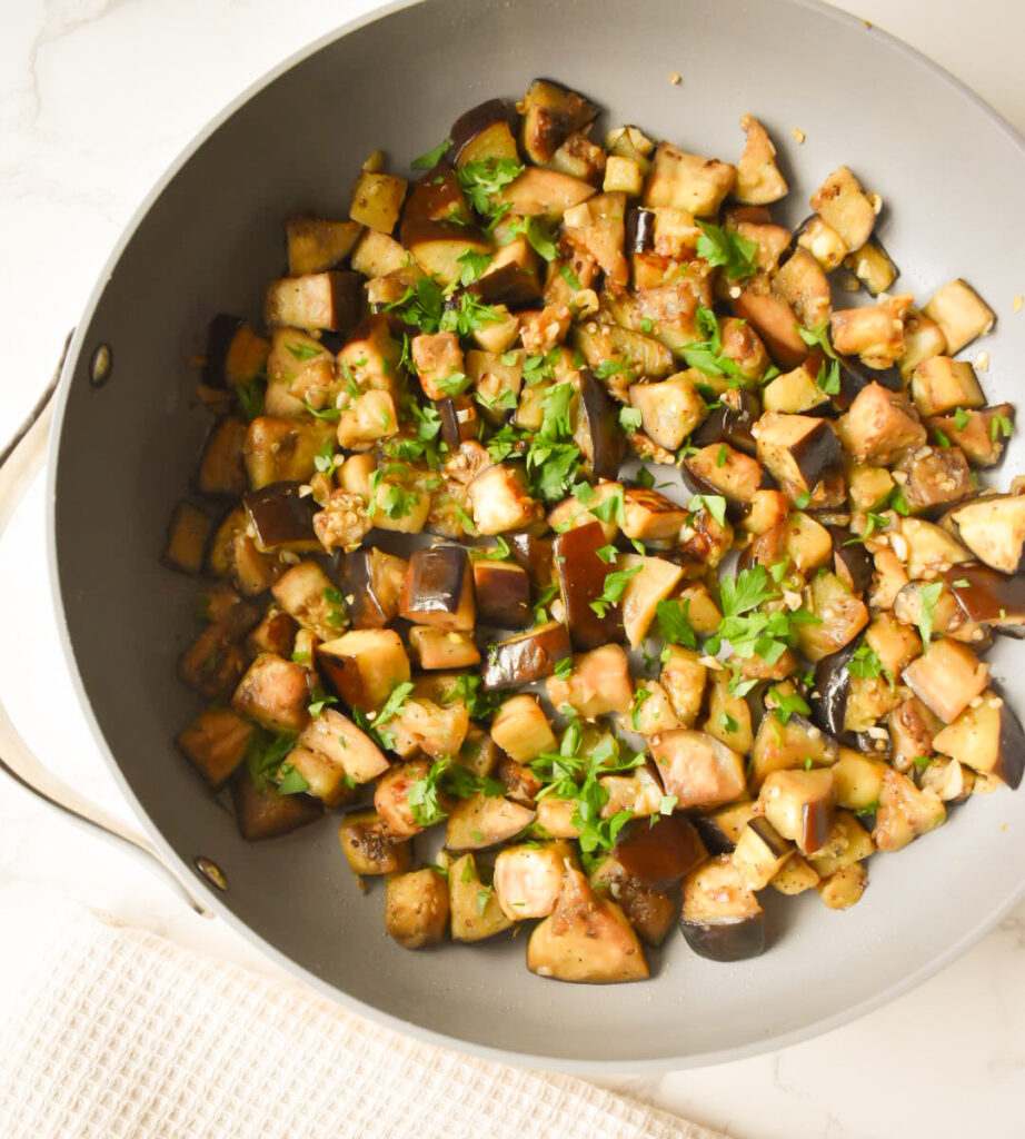Garlic sautéed eggplant cooking in a skillet