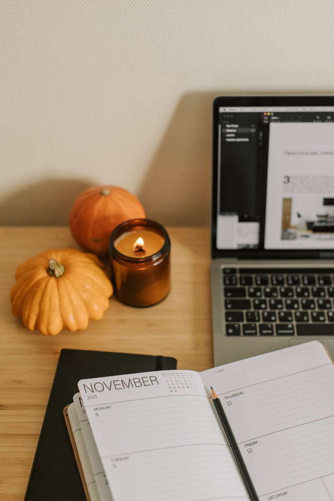 Inviting home office setup with a candle, pumpkins, and planner.