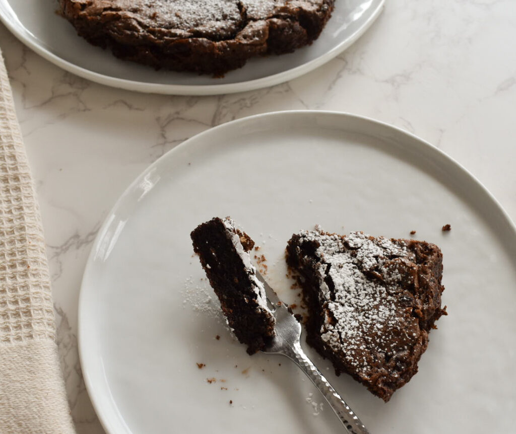 Flourless chocolate cake sliced to show fudgy center