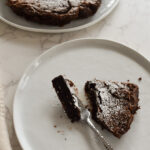 Flourless chocolate cake sliced to show fudgy center