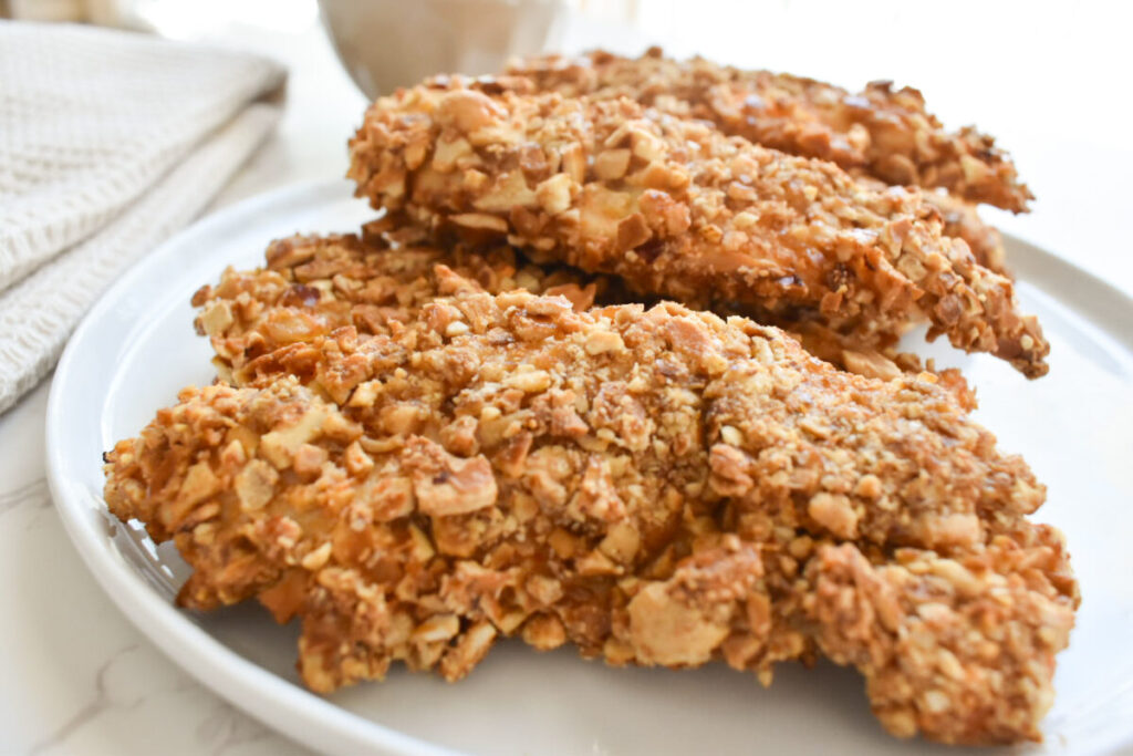 Close-up of crunchy pretzel crusted chicken sliced on plate