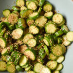 Sesame Ginger Baby Cucumber Salad served in a bowl with sesame seeds and scallions