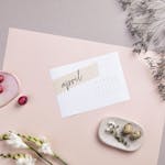 Flat lay of April calendar with florals, painted eggs, and pastel colors for Easter decoration.