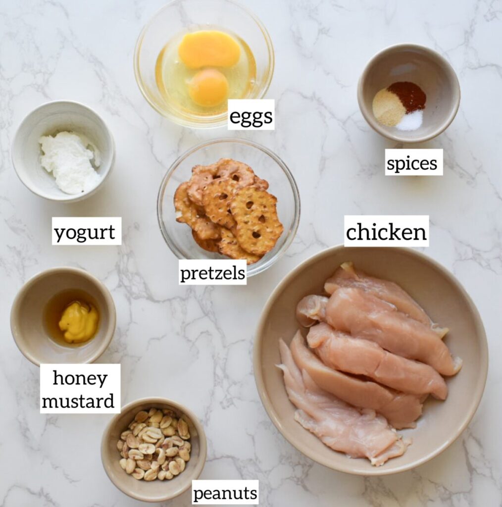 Ingredients in Pretzel peanut crusted chicken in air fryer basket golden and crispy