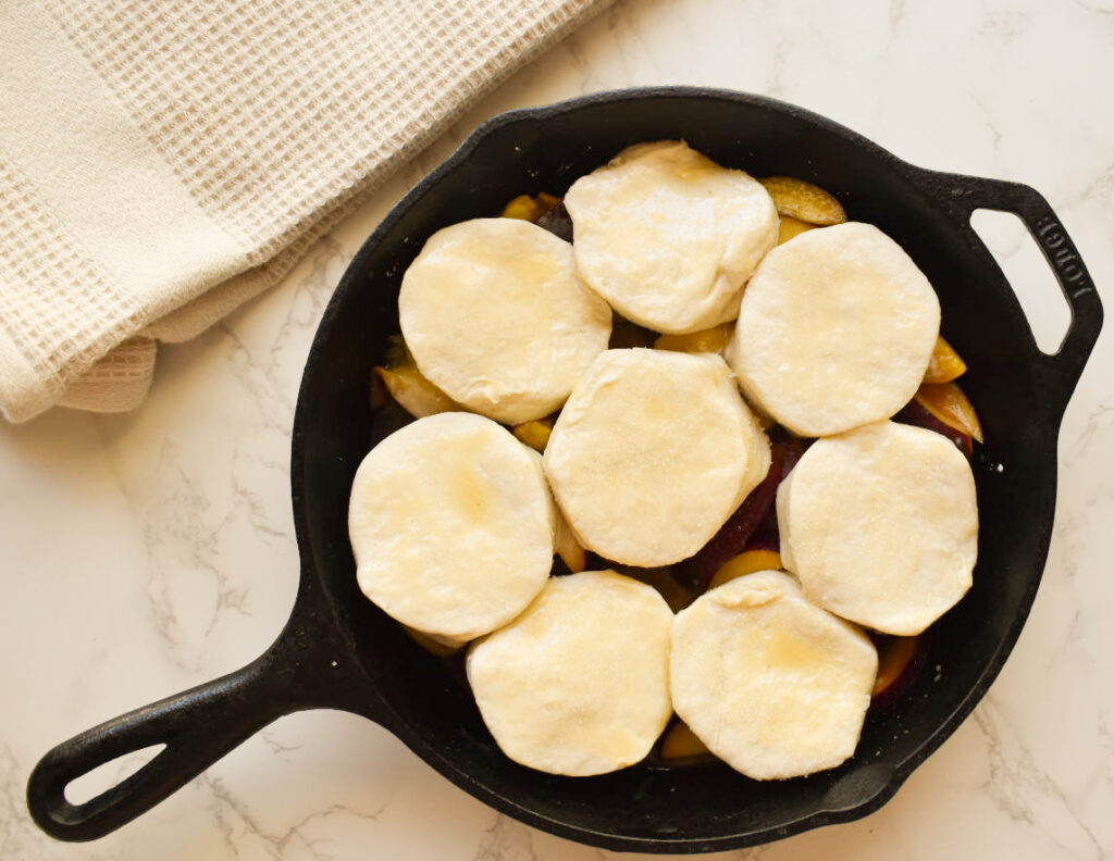 Close-up of peach cobbler with syrupy filling