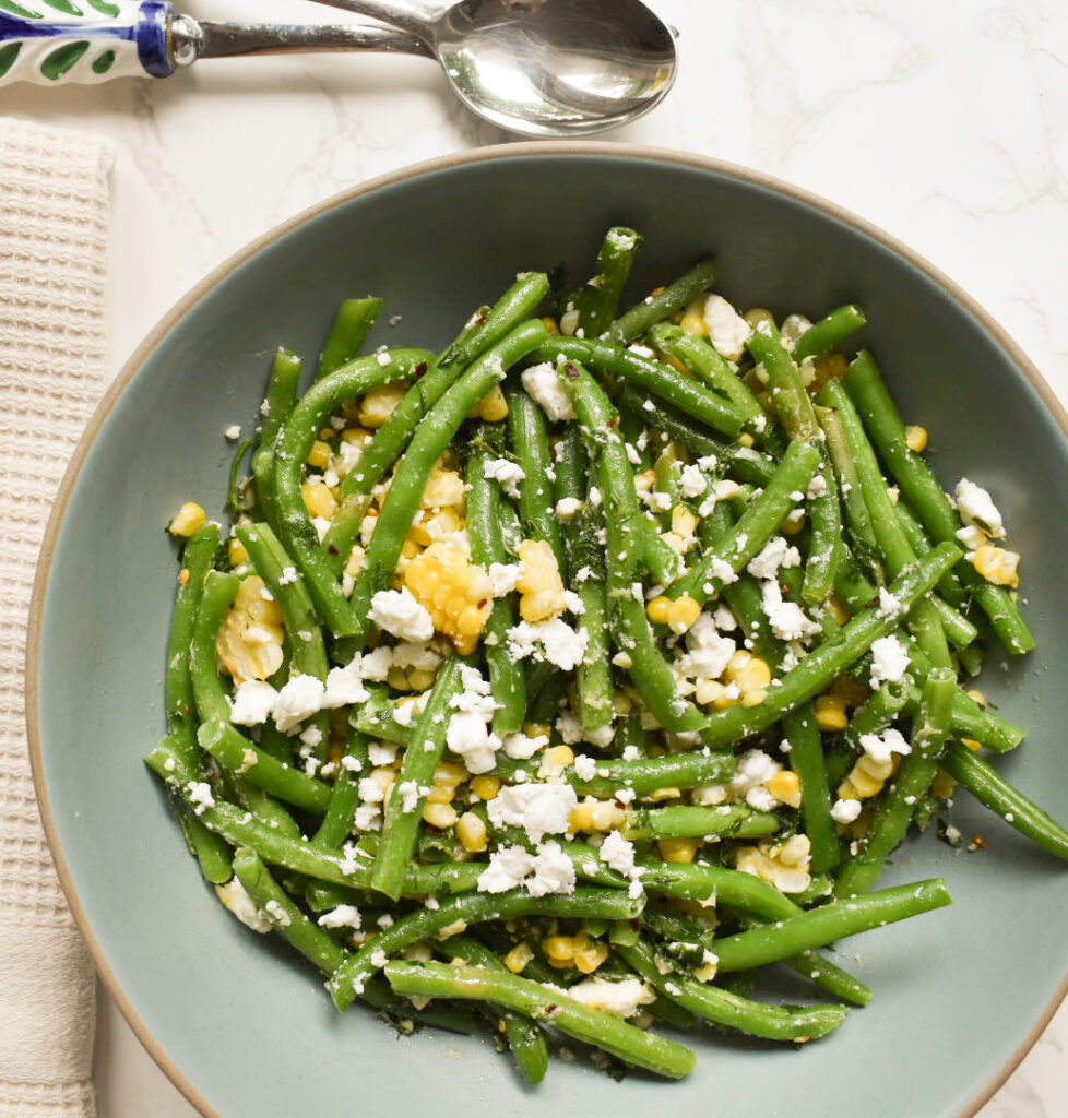 String Bean Corn and Feta Salad served in a white bowl with fresh dill and parsley
