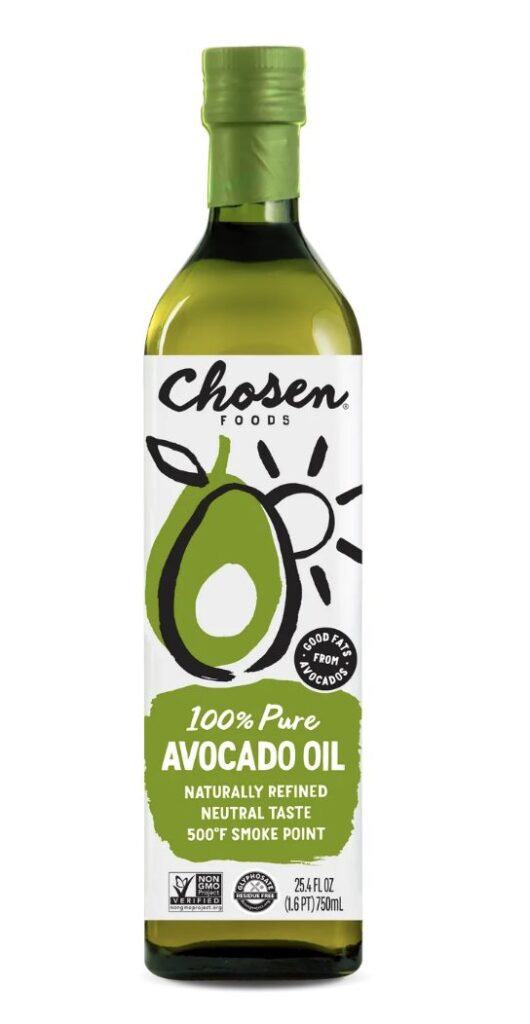 Avocado oil bottle on kitchen counter with fresh vegetables