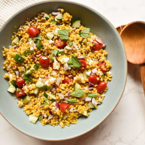 Mediterranean Israeli couscous salad with cucumber, tomatoes, feta, mint, and sunflower seeds