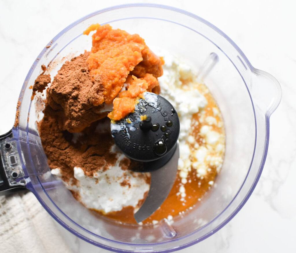 Cottage cheese mixed with pumpkin puree and pumpkin pie spice in a bowl.