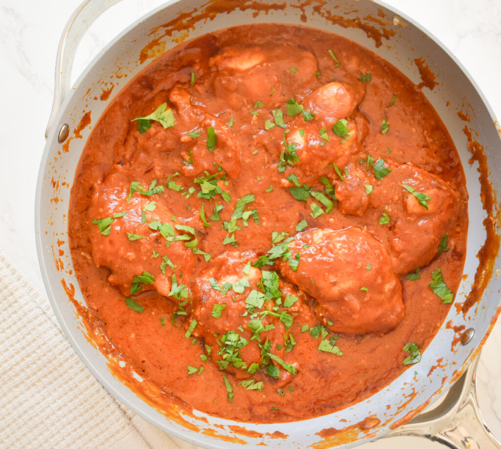Close-up of creamy chicken tikka masala with a rich tomato and coconut milk sauce.